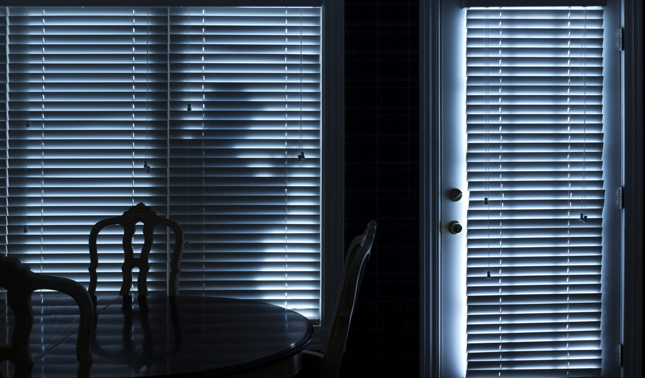 Silhouette eines Einbrechers, der nachts zur Hintertür schleicht