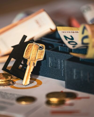 Ein Miniatur Haus mit Schlüssel und Geldscheinen