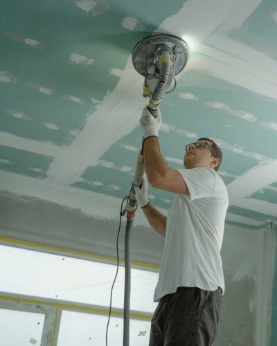 Handwerker schleift eine Zimmerdecke