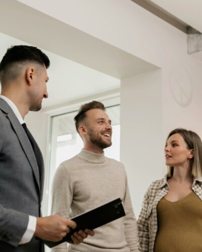 Junges Paar mit Makler bei einer Immobilienbesichtigung