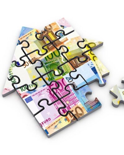 Puzzle in Form eines Hauses. Auf dem Puzzle ist Geld zu sehen.